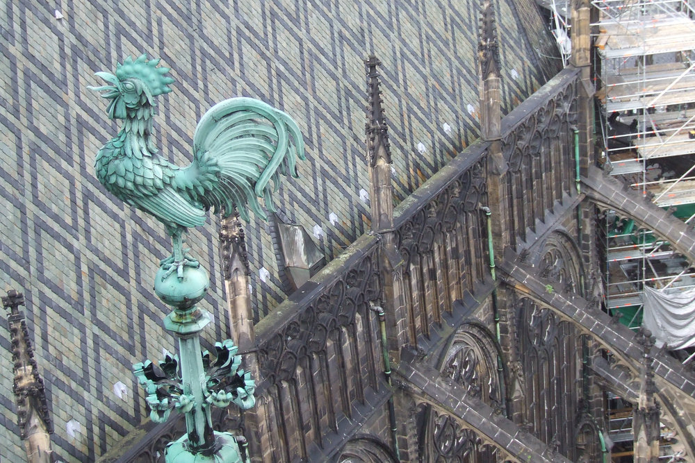 Green copper rooster weather vane on the Gothic roof of St. Vitus Cathedral Prague