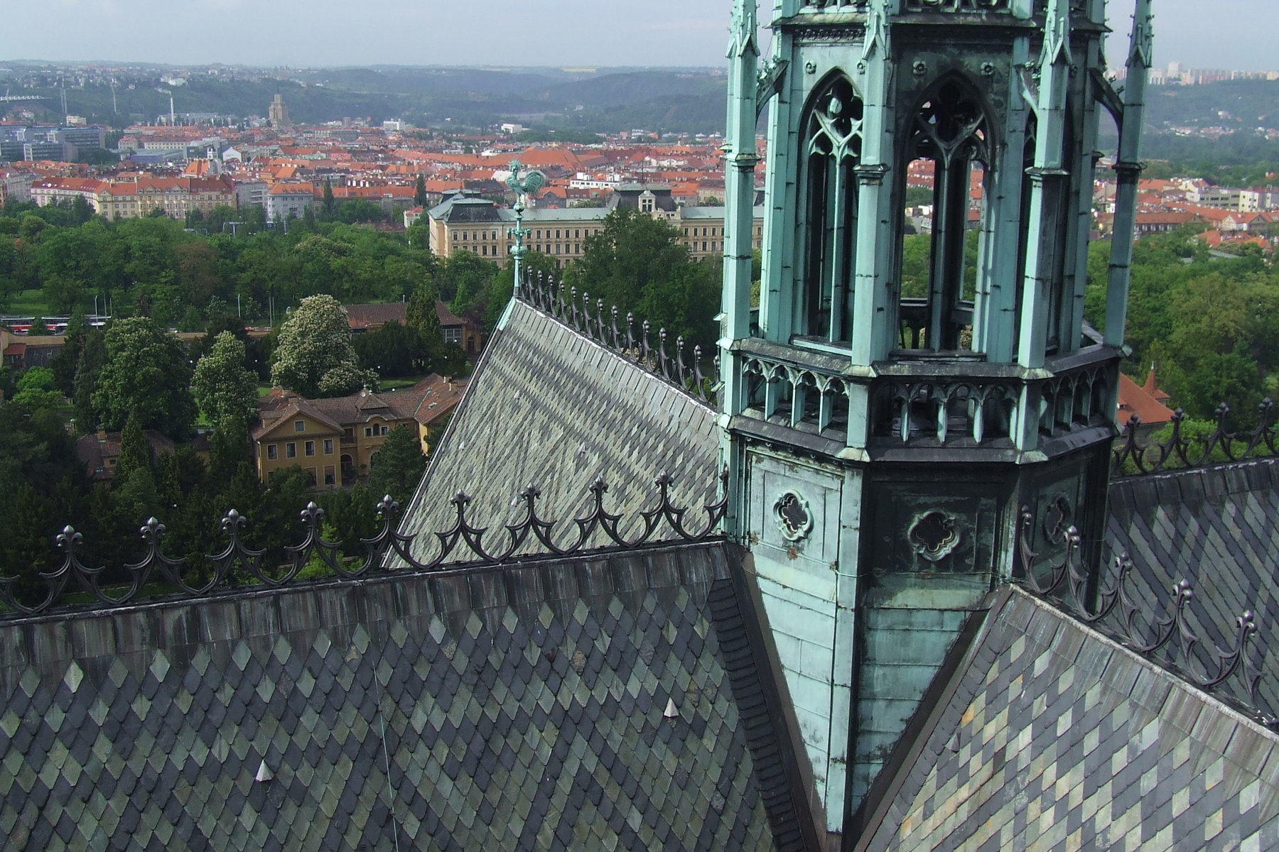 Green copper roof and Neo-Gothic tower of St. Vitus Cathedral with Prague panorama