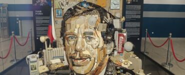 Anamorphic art installation of Václav Havel's face made from vintage objects at Prague Airport