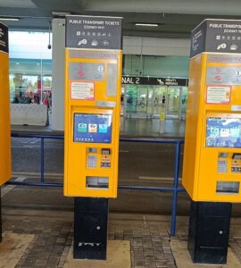 Yellow public transport ticket vending machine at Prague Airport arrivals hall
