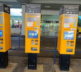 Yellow public transport ticket vending machine at Prague Airport arrivals hall