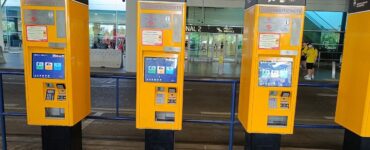 Yellow public transport ticket vending machine at Prague Airport arrivals hall