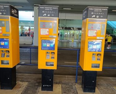 Yellow public transport ticket vending machine at Prague Airport arrivals hall