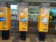 Yellow public transport ticket vending machine at Prague Airport arrivals hall