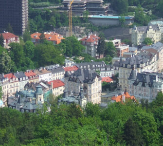 Panoramic skyline view of Karlovy Vary spa town surrounded by green hills