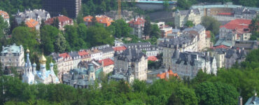 Panoramic skyline view of Karlovy Vary spa town surrounded by green hills
