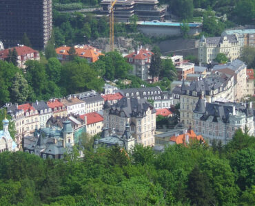 Panoramic skyline view of Karlovy Vary spa town surrounded by green hills