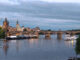 Prague river cruise on the Vltava River at sunset with Charles Bridge, sightseeing boats and the historic Old Town skyline.